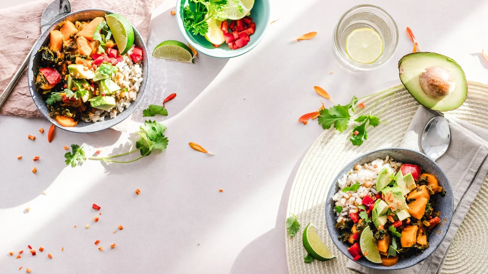 Twee kommen met groente, avocado en peulvruchten van bovenaf: afvallen tips in de praktijk