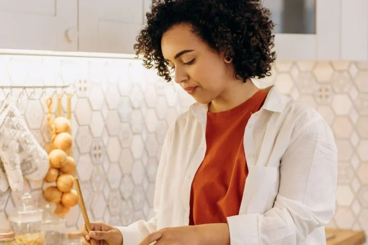 Vrouw maakt een verse salade in een lichte keuken