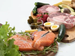 Zalm, vlees, eieren en kaas op een plank: hoeveel eiwitten per dag haal je uit deze producten?