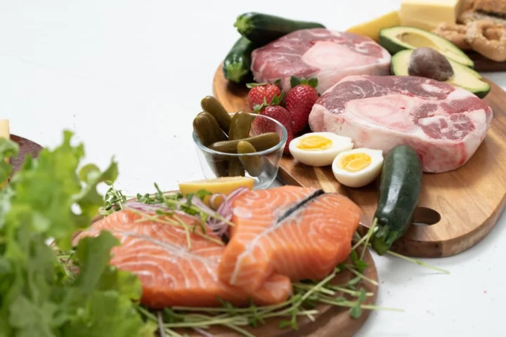 Zalm, vlees, eieren en kaas op een plank: hoeveel eiwitten per dag haal je uit deze producten?