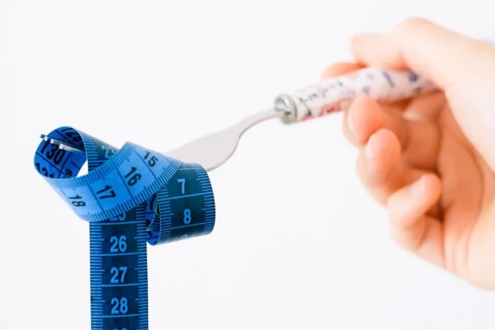 Hand houdt een vork vast met een centimeter eromheen gewikkeld
